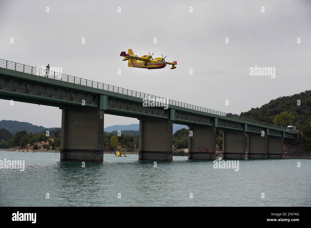 Bathers watch Securite Civile aircarft collecting water at Lac de Saint-Cassien to put out wildfires  in Cote d'Azur, Southern France, Mediterranean Stock Photo