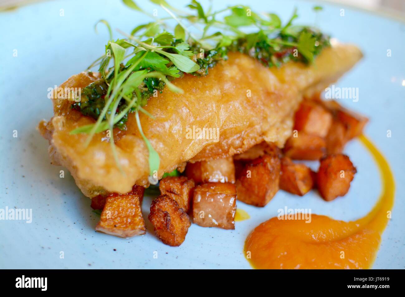 Gourmet battered fish with fried sweet potatoes Stock Photo