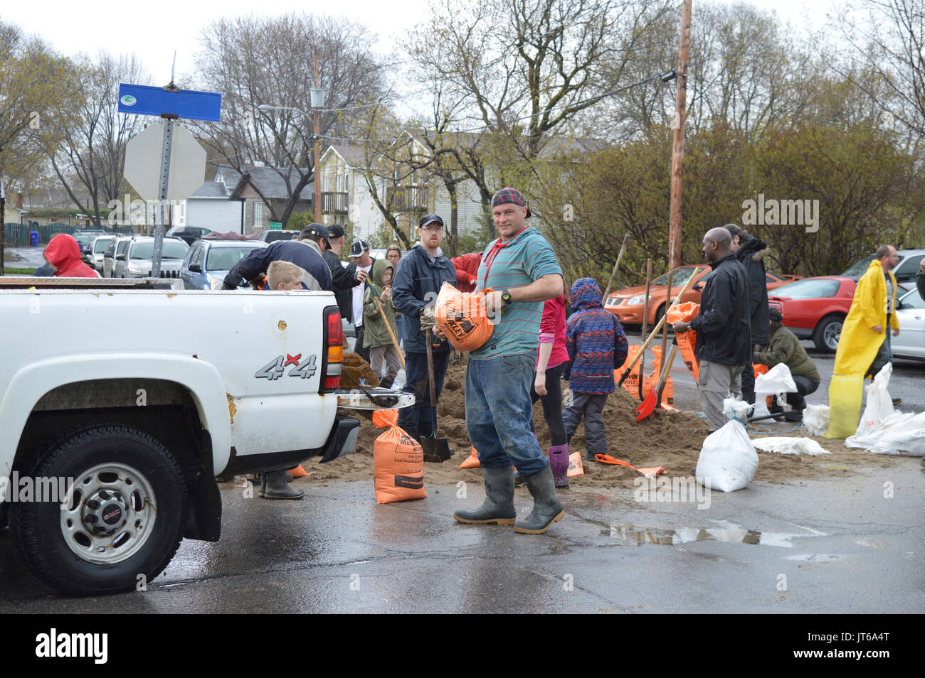 Residents and neighbors band together to fill sand bags in an effort to stop homes from flooding.  Gatineau, Quebec, Canada, Spring 2017 Stock Photo