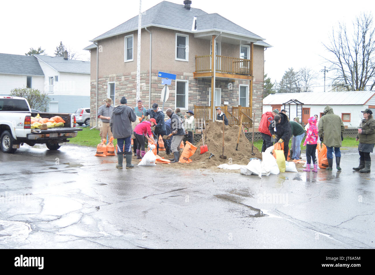 Residents and neighbors work together to fill sand bags.  Hoping to protect houses from the rising flood waters in the Spring of 2017 Stock Photo