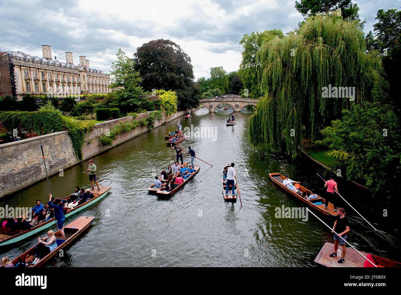 Tourists enjoying a punt along the River Cam passing under historic stone bridges and besides famous colleges of Cambridge University in England. Stock Photo