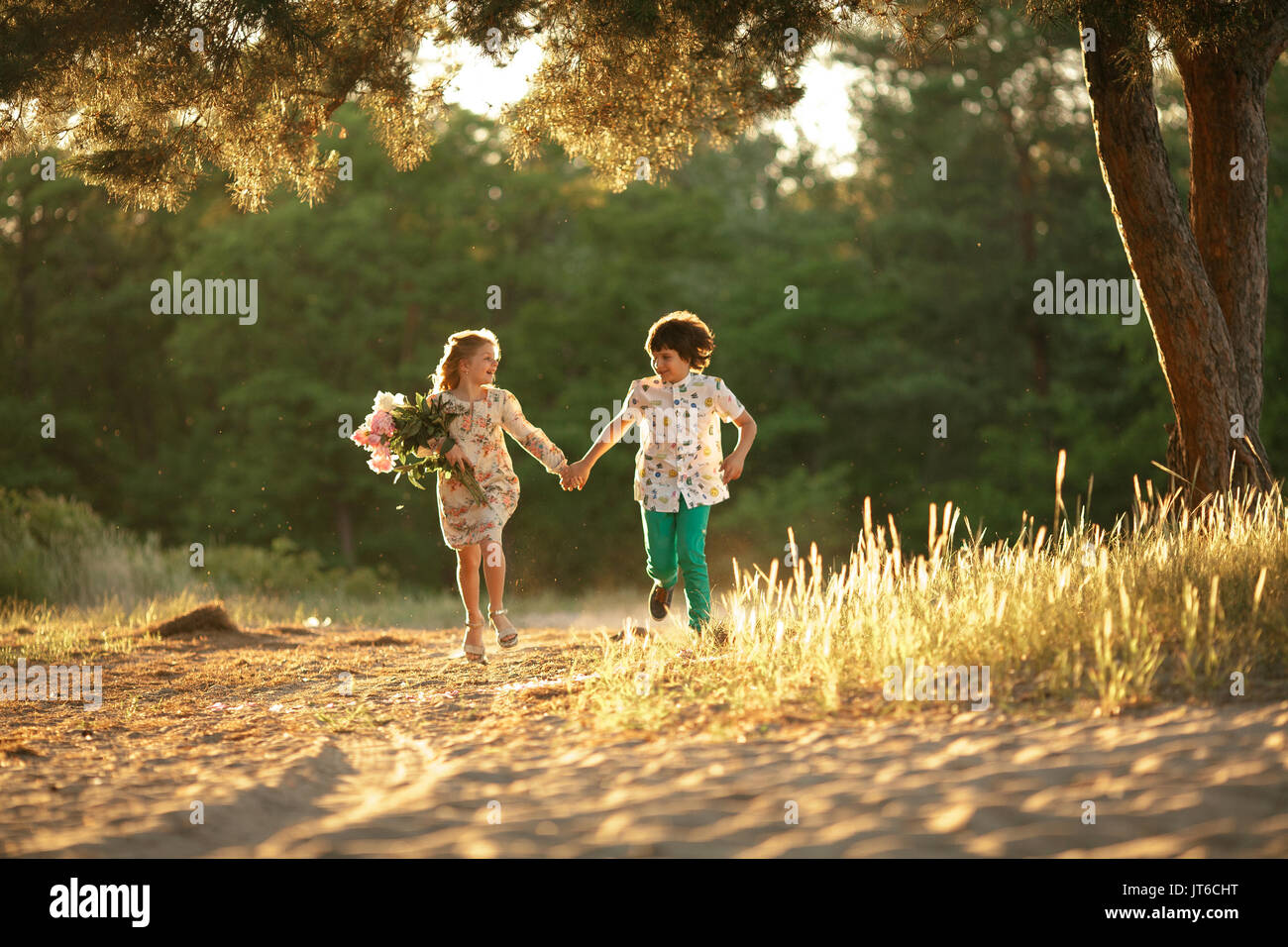 Little Girl With Bouquet And Boy Are Running In Sunny Forest Road And Holding Hands First Love Stock Photo Alamy Little Girl With Bouquet And Boy Are Running In Sunny Forest Road And Holding Hands First Love Stock Photo Alamy