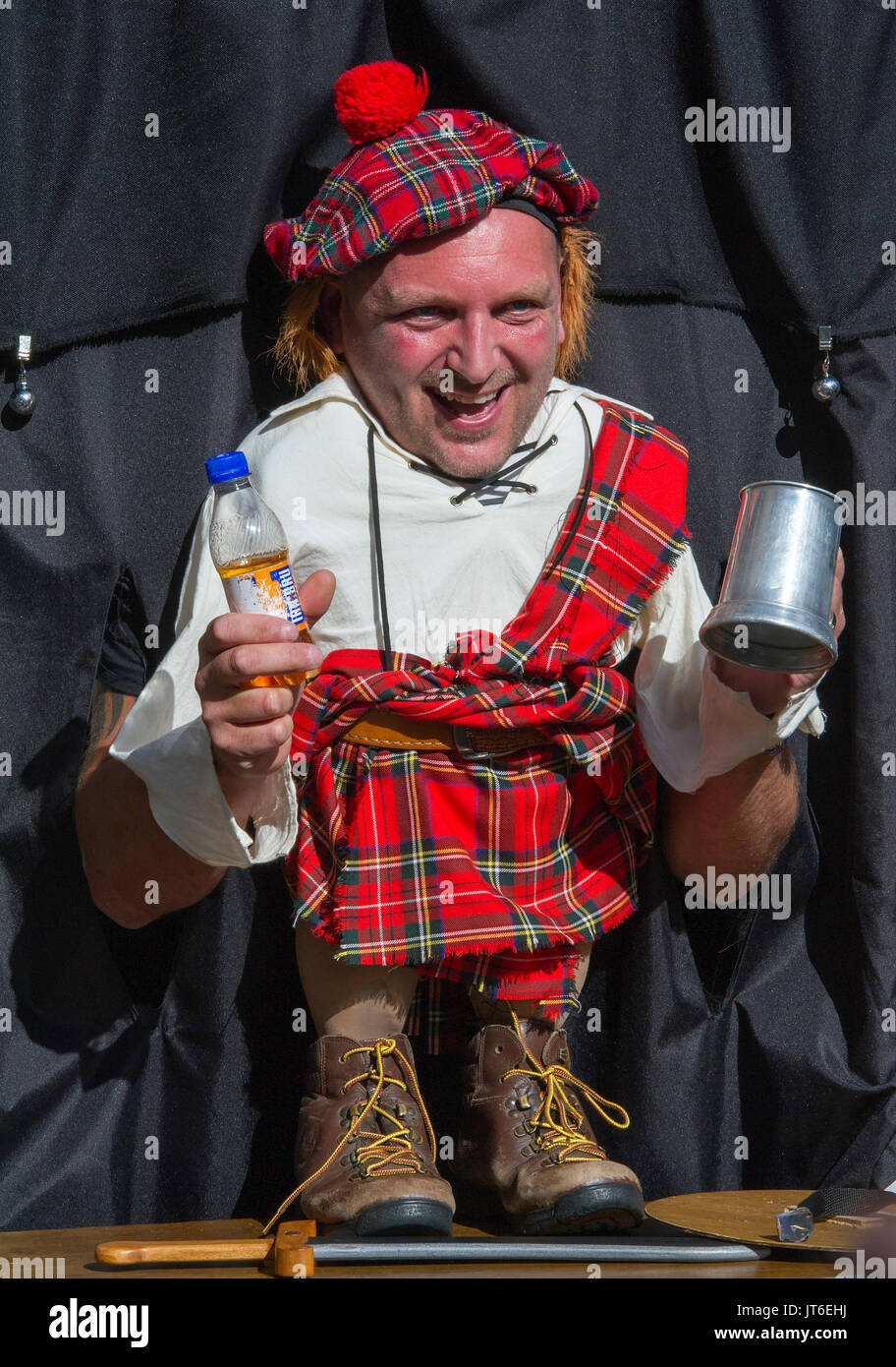 A tourist poses as a Scottish Highlander at a novelty stall on the Royal Mile during the Edinburgh Festival Fringe. Stock Photo