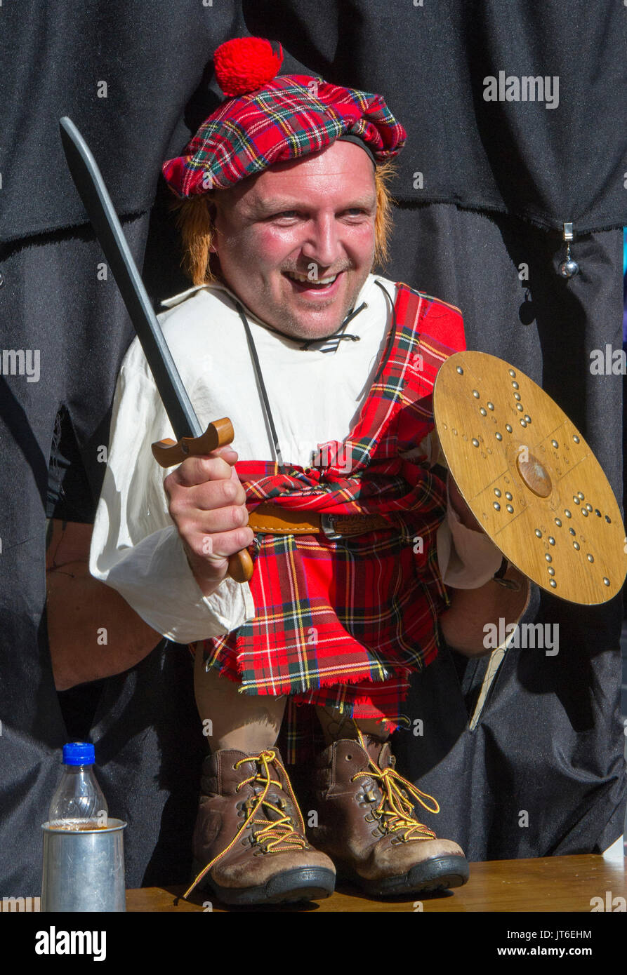 A tourist poses as a Scottish Highlander at a novelty stall on the Royal Mile during the Edinburgh Festival Fringe. Stock Photo