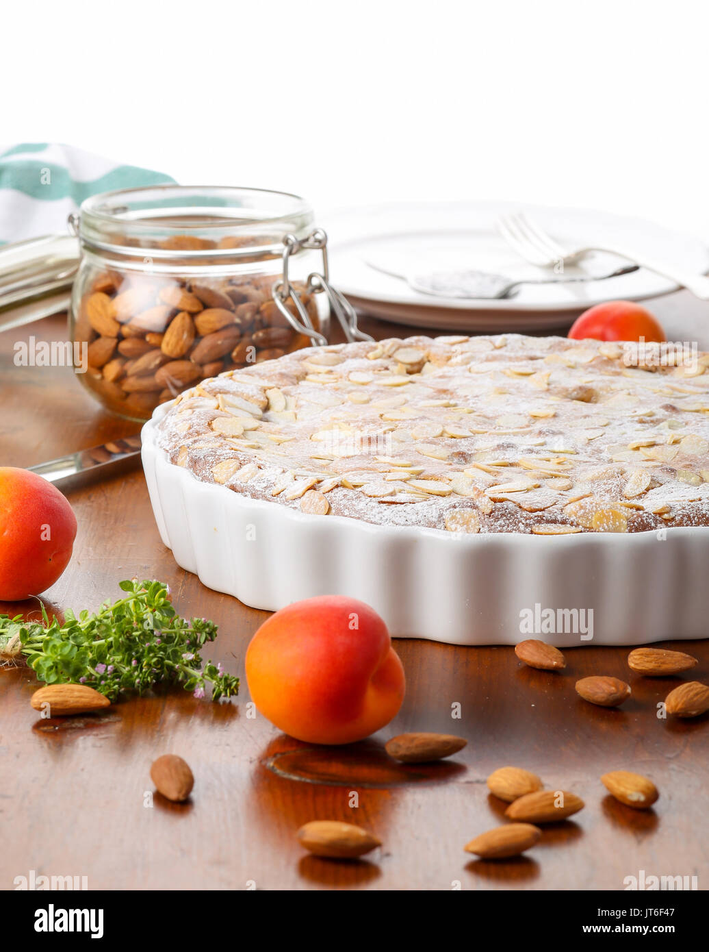 Crustless apricot frangipane tart with almonds and aromatic lemon thyme on rustic brown pine table Stock Photo