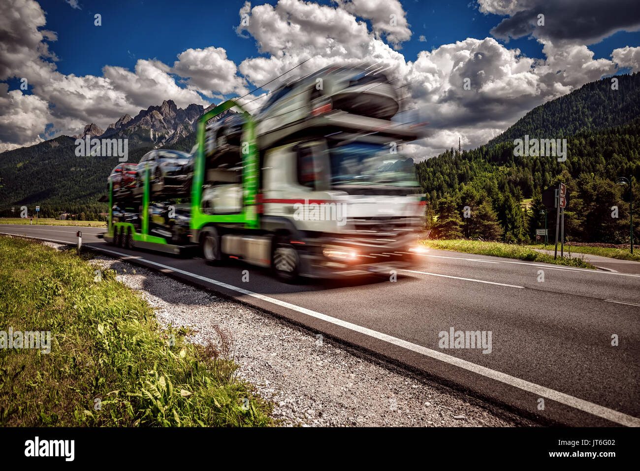 Truck trailer transports new cars rides on highway Stock Photo