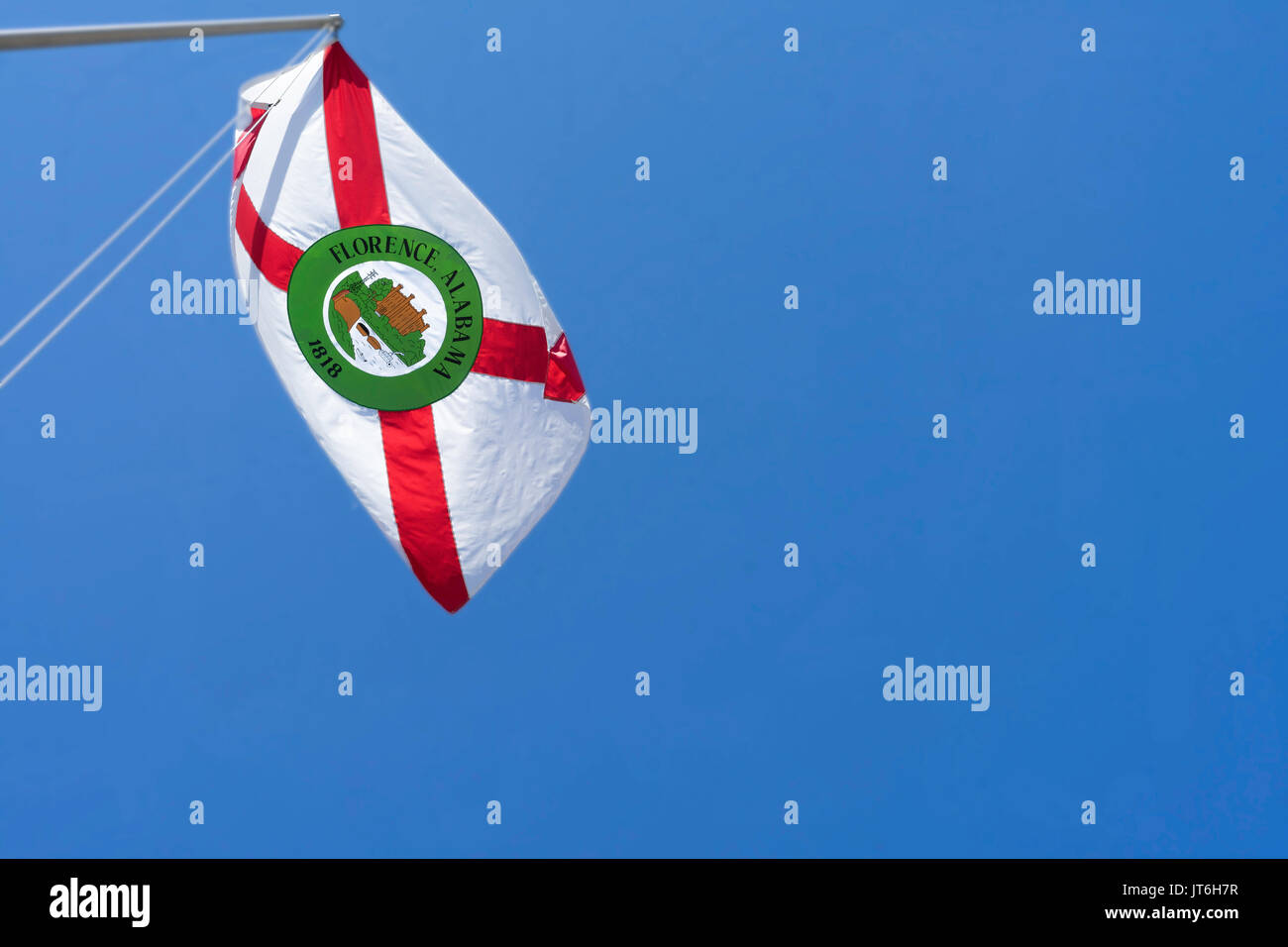 The flag of Florence, Alabama flutters in the breeze above the Tennessee River. Stock Photo