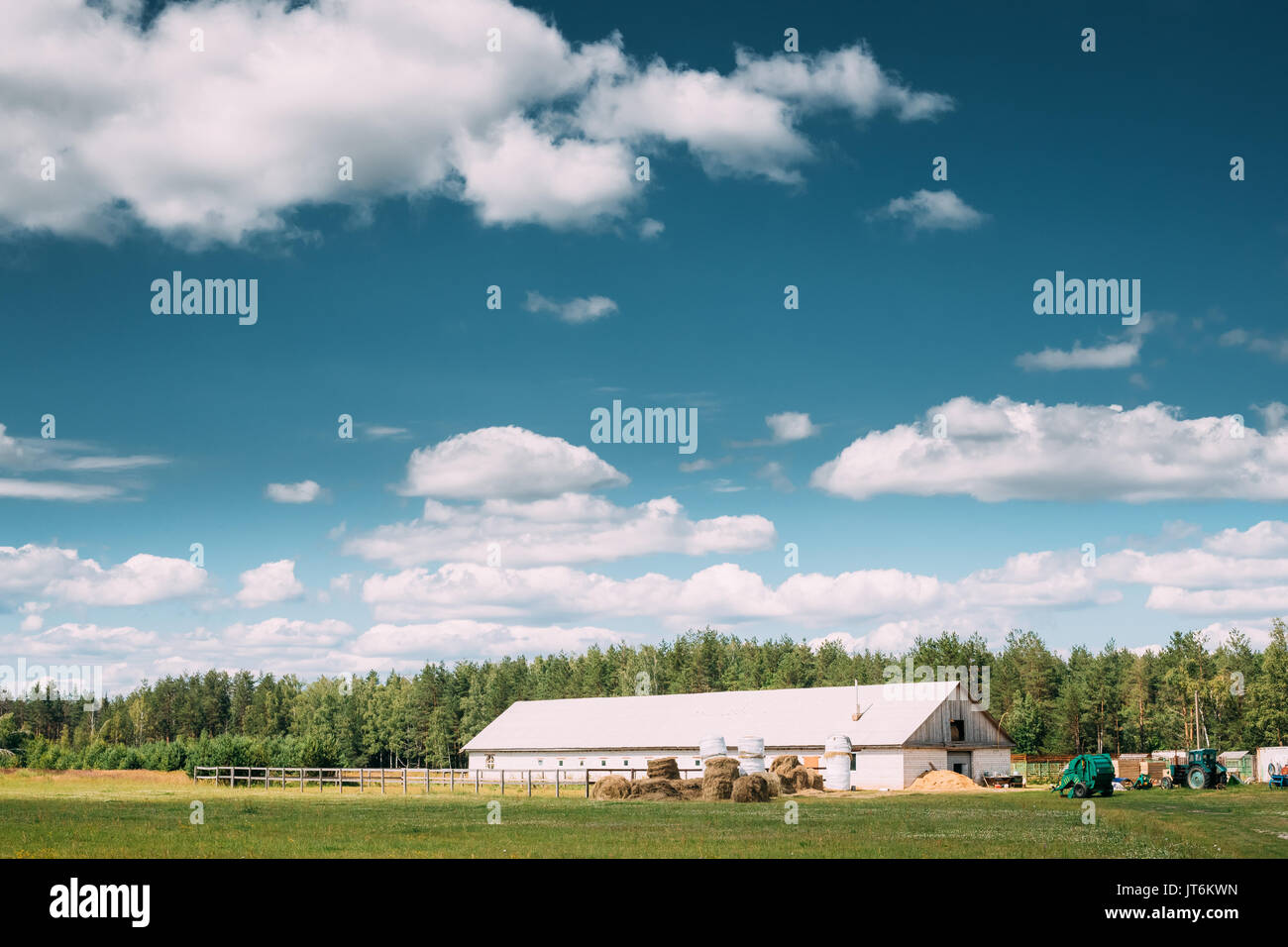 Countryside Rural Landscape With Paddock For Horse, Shed Or Barn Or Stable With Haystacks In Lat Summer Season. Agricultural Rural Landscape At Sunny  Stock Photo