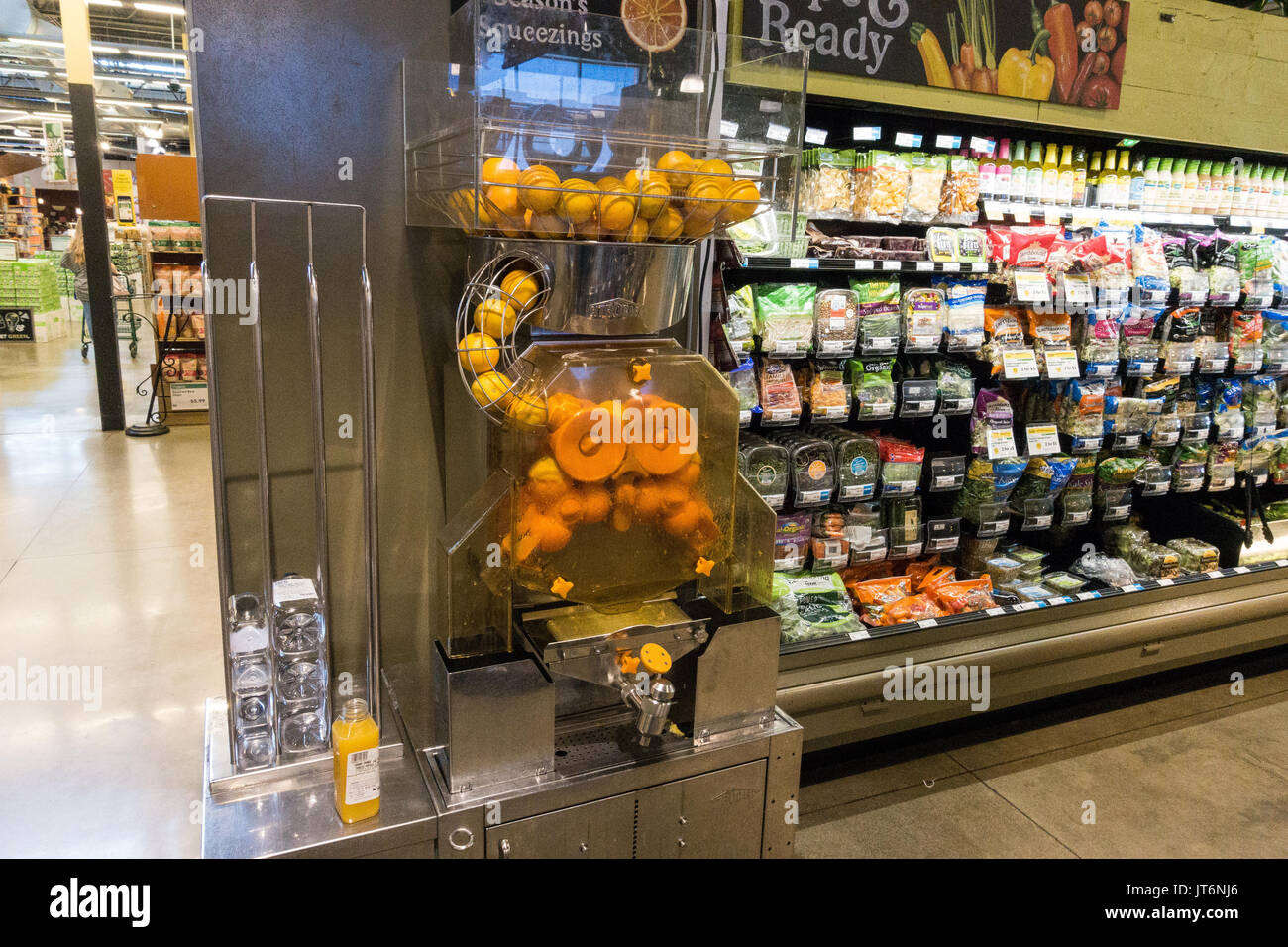 Self served orange juicer - fresh squeezed orange juice machine at the Whole Food Market store Stock Photo