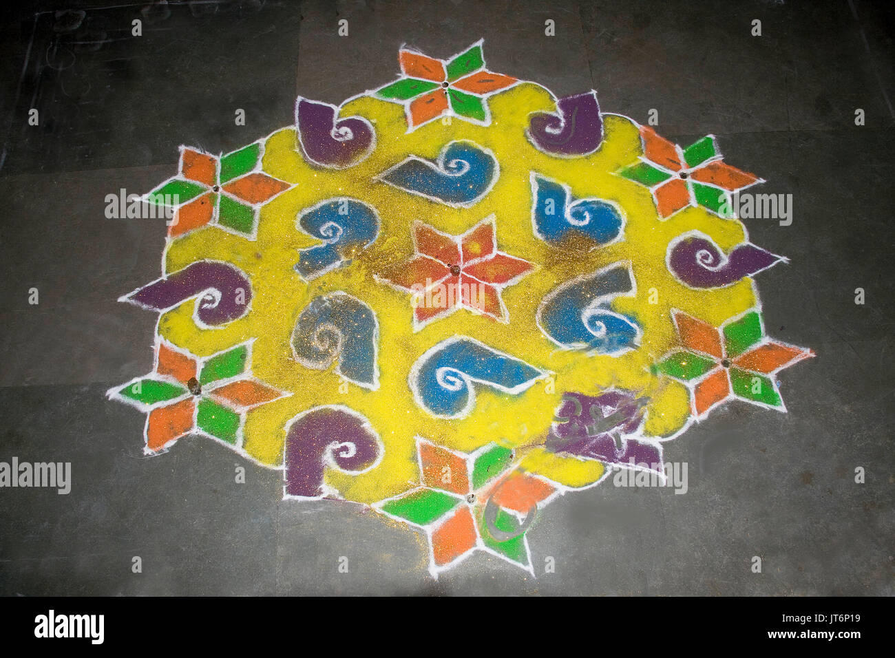 Creation of floral designs in Rangoli art using stone powder mixed with