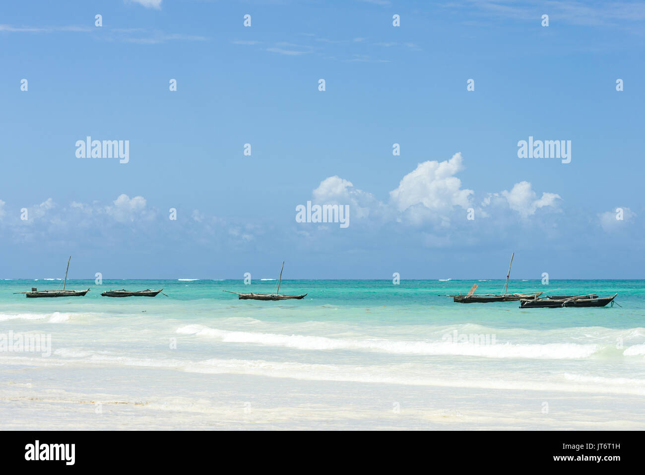 Traditional dhow wooden fishing boats anchored off shore, Diani beach, Kenya Stock Photo