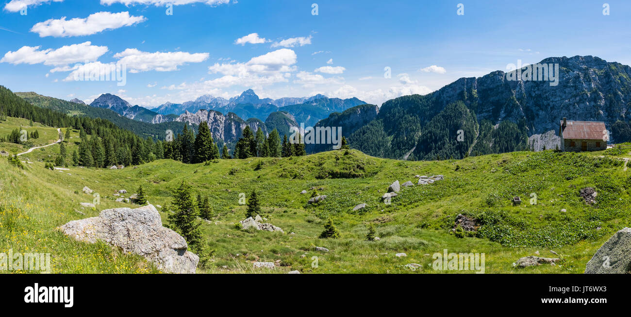 View from Auernig Alm with old huts on Nassfeld in Carnic Alps to Julian Alps in Italy Stock Photo
