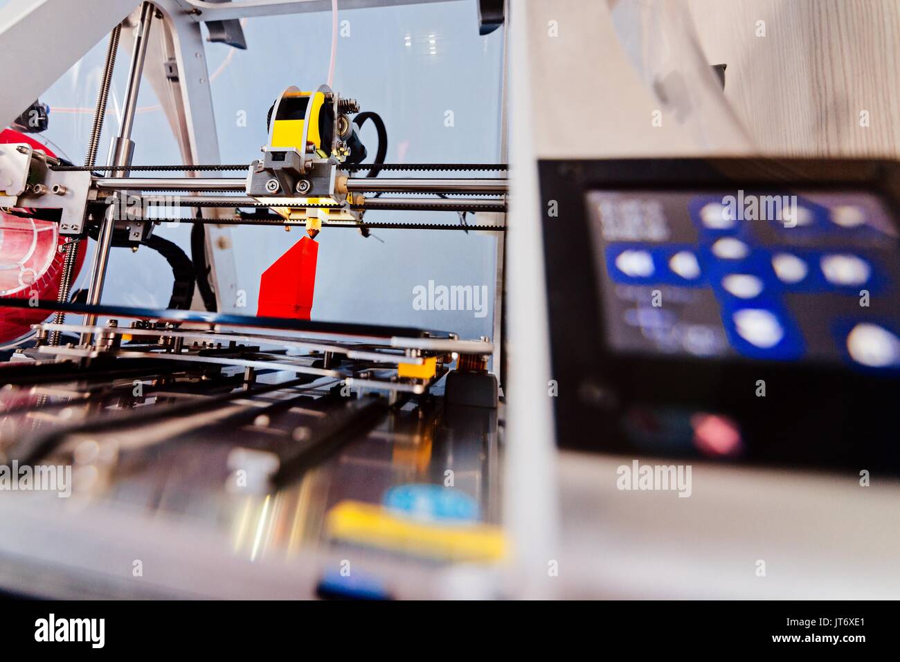 3d printer working and printing red plastic component Stock Photo
