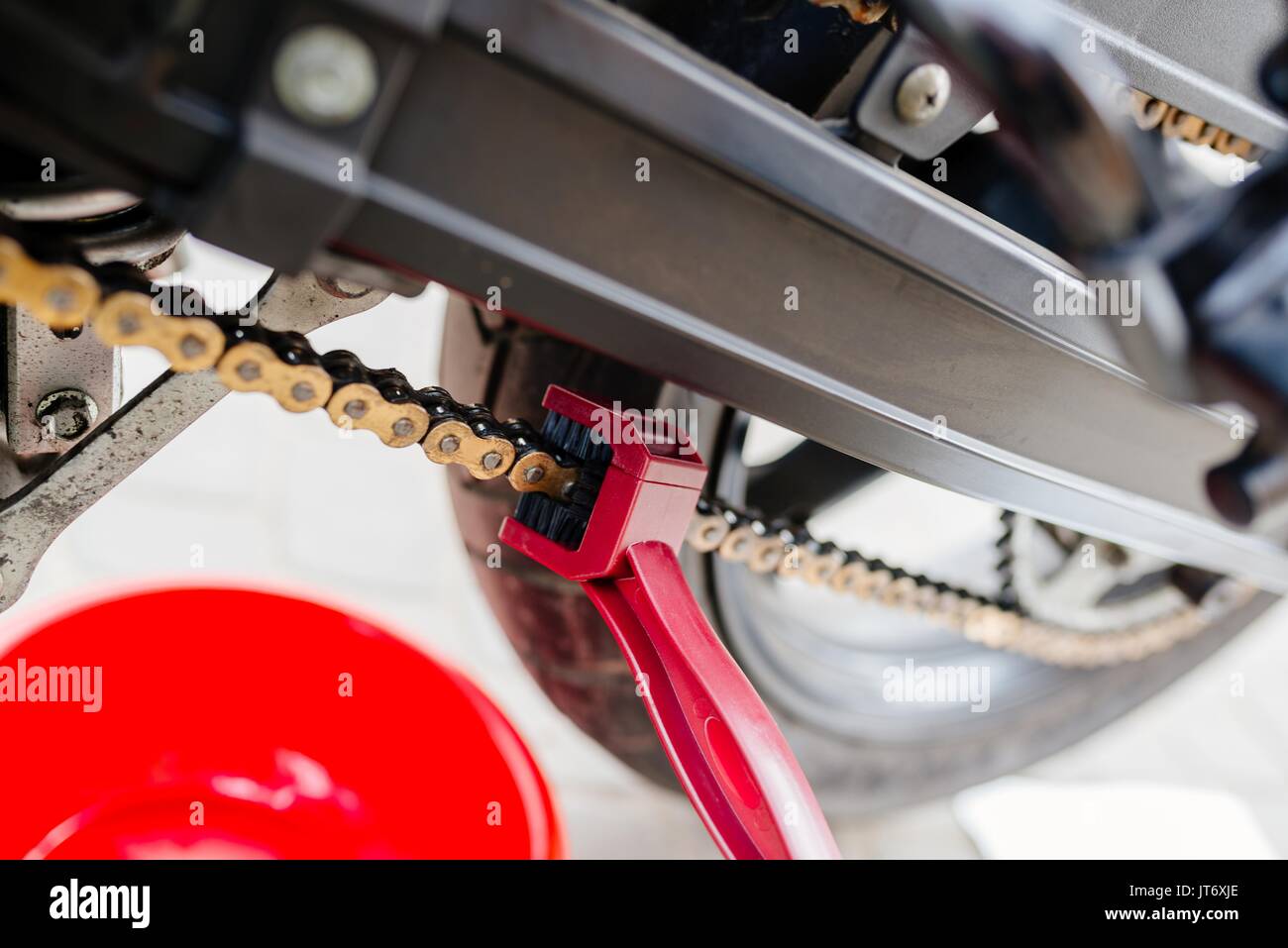 Cleaning motorcycle chain with dedicated chain brush Stock Photo Alamy