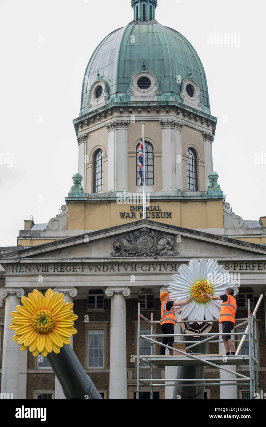 The final adjustments are made to flowers which have been temporarily placed on the 15-inch naval guns positioned in front of the Imperial War Museum, London, to mark the final weeks of IWM London's People Power: Fighting for Peace exhibition. Stock Photo