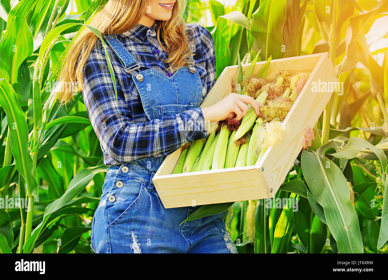 Harvest time concept. Portrait of beautiful farmer girl in coveralls ...