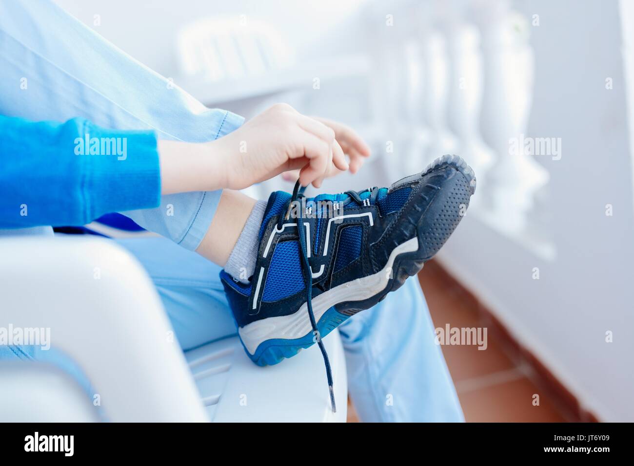 Young boy tying shoe hi-res stock photography and images - Alamy