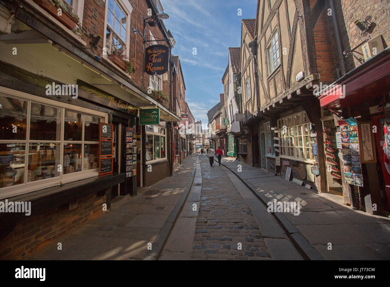 Historic shops lining ancient narrow cobbled street in The Shambles in city of York, England Stock Photo