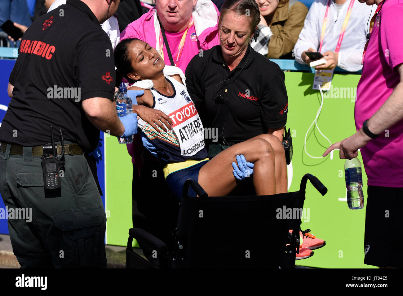 Monika Athare of India collapsed after crossing the finish line at the end of the IAAF World Championships 2017 Marathon race in London UK. Paramedics Stock Photo