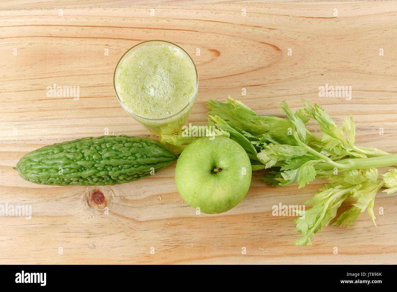 Green apple, bitter gout and celery isolated on wooden background to