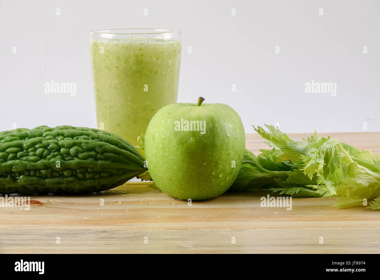 Green apple, bitter gout and celery isolated on wooden background to