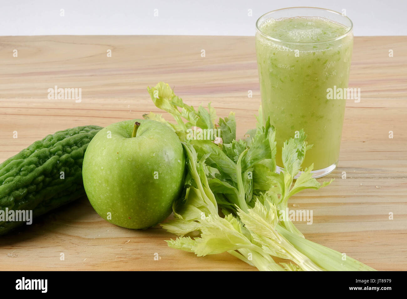 Green apple, bitter gout and celery isolated on wooden background to