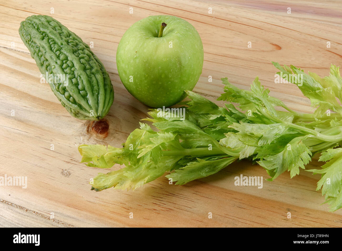 Green apple, bitter gout and celery isolated on wooden background to