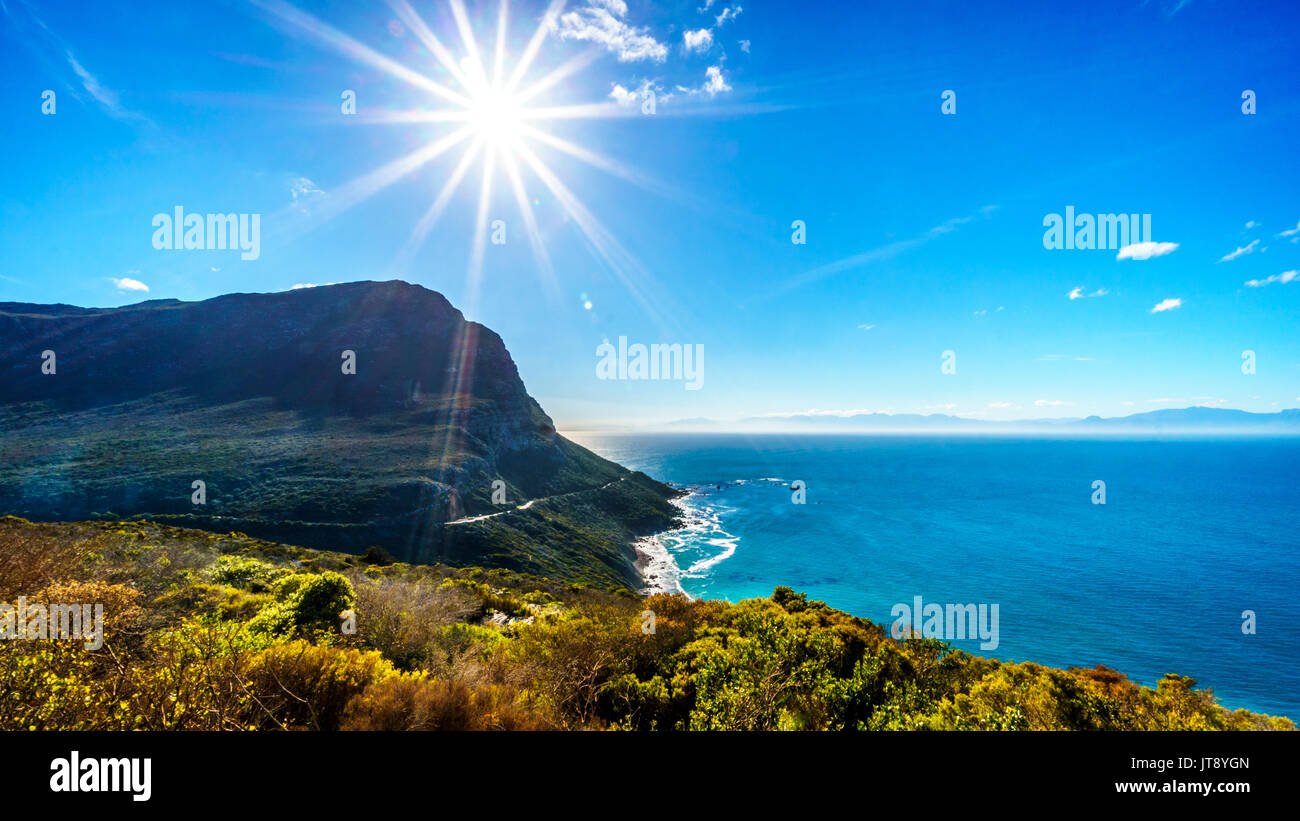 Low winter sun casting its rays over Smitswinkel Bay on the Cape Peninsula in the Western Cape province of South Africa under blue sky Stock Photo