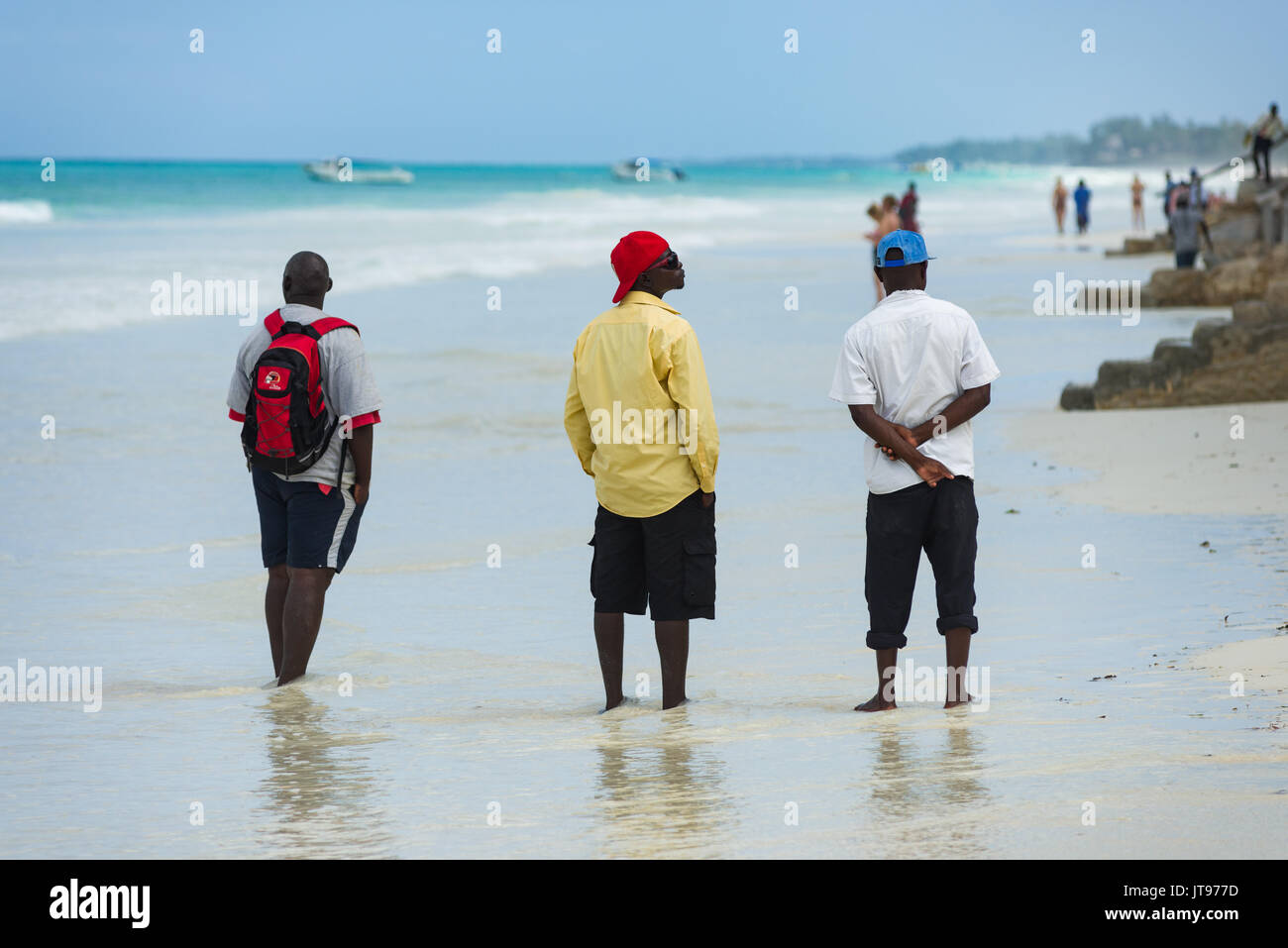 Local sellers wait on the beach by nearby resort for tourists, Diani, Kenya Stock Photo