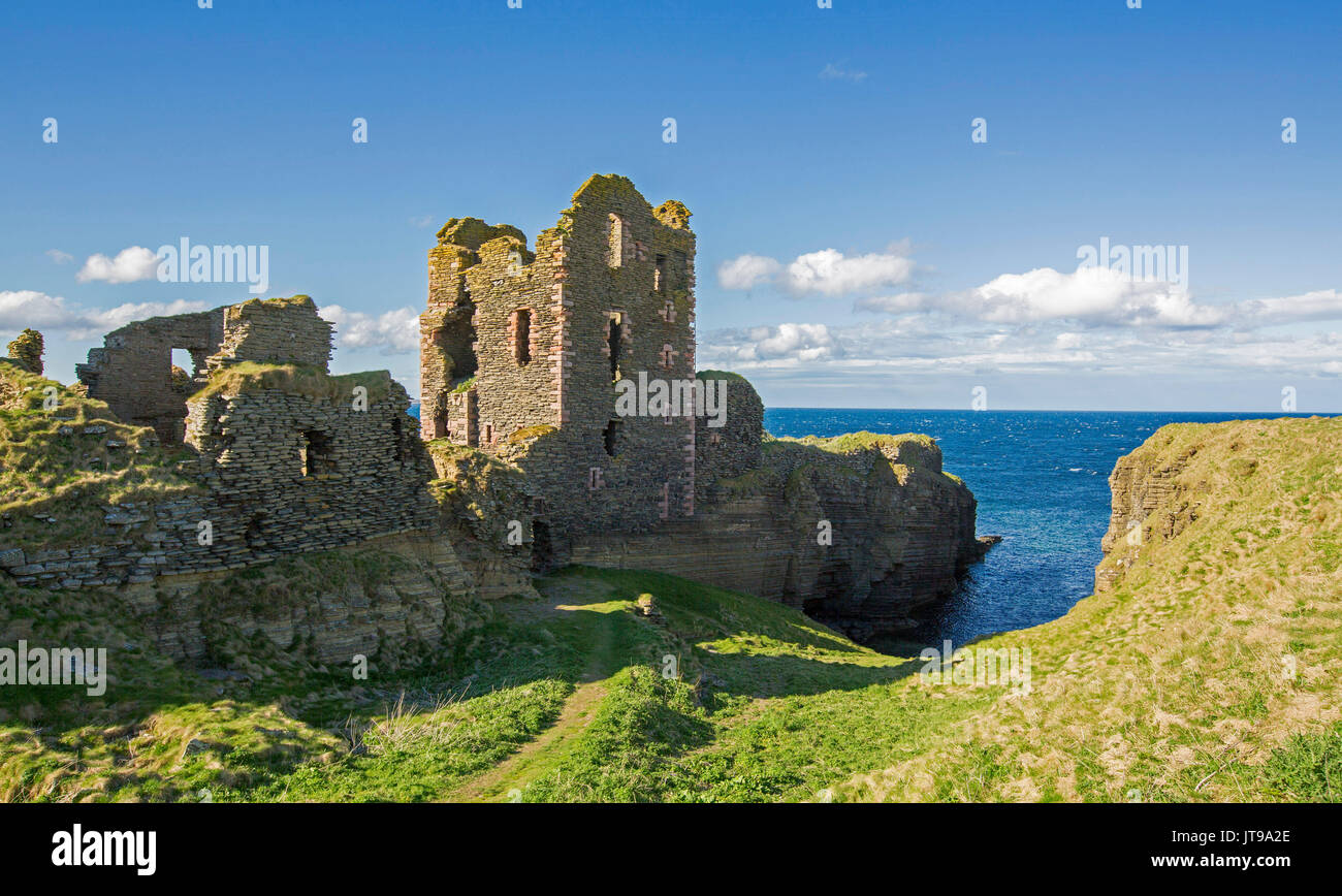 Panoramic view of ruins of Sinclair Girnigoe castle on clifftop with background of blue ocean under blue sky at Noss Head, near Thurso, Scotland Stock Photo