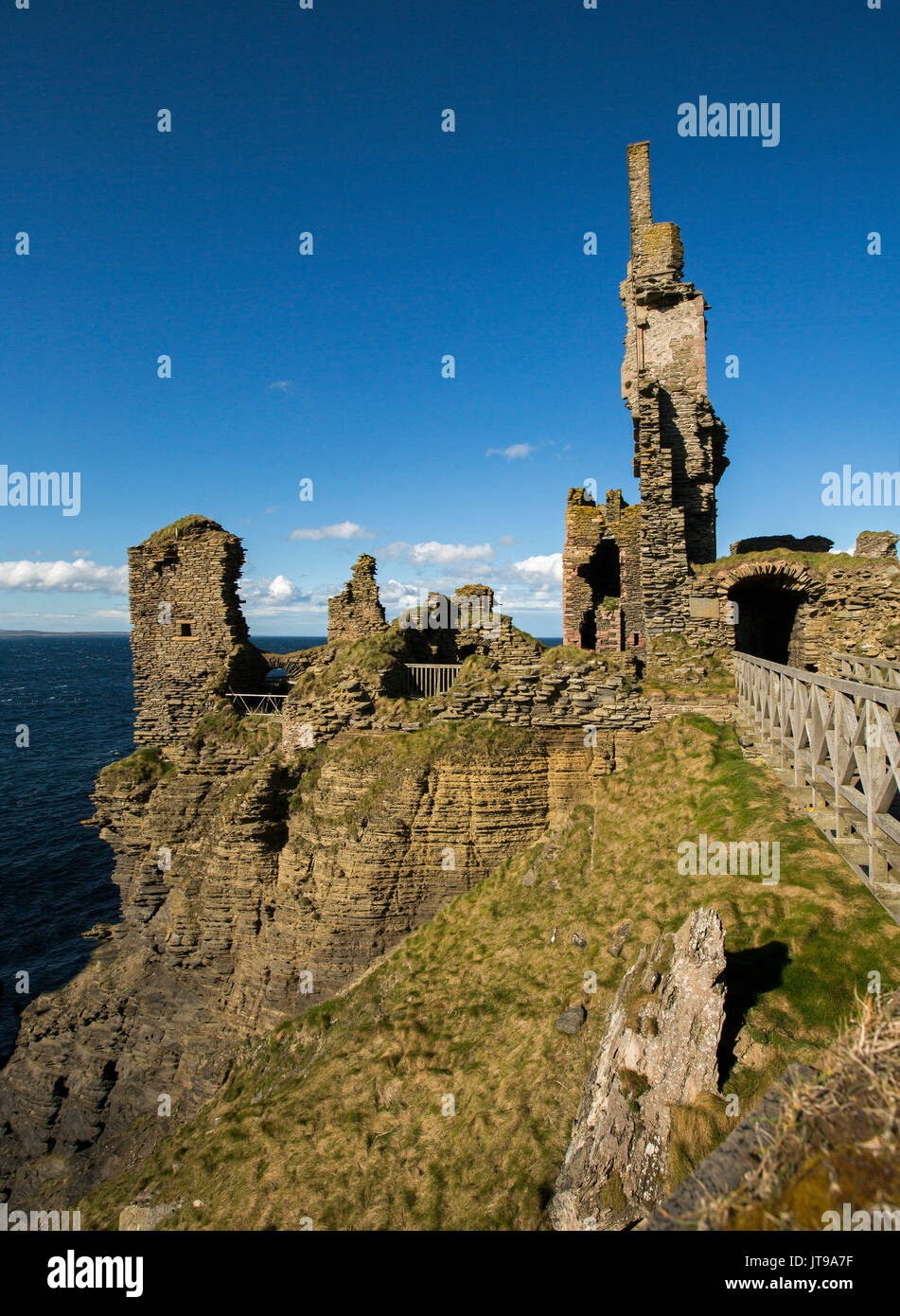 Ruins of Sinclair Girnigoe castle on clifftop with background of blue ocean under blue sky at Noss Head, near Thurso, Scotland Stock Photo