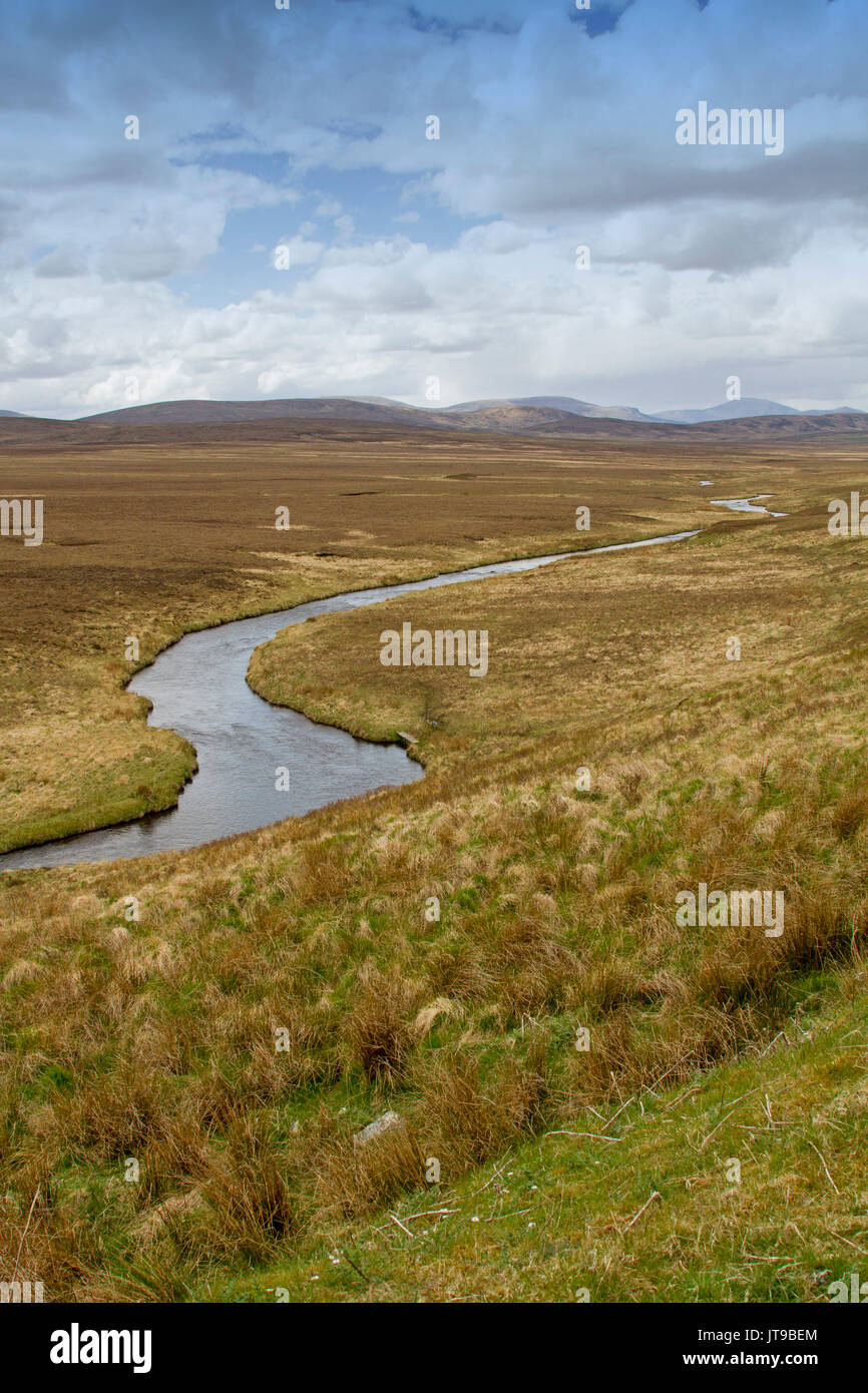 Vast treeless landscape in Scottish highlands with stream snaking