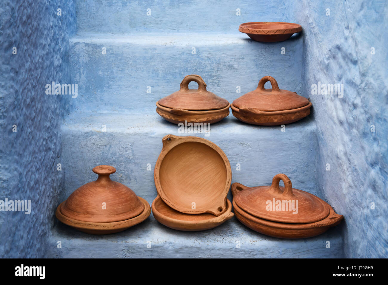 Empty traditional moroccan tagine (tajine) on blue painted stairs. Stock Photo
