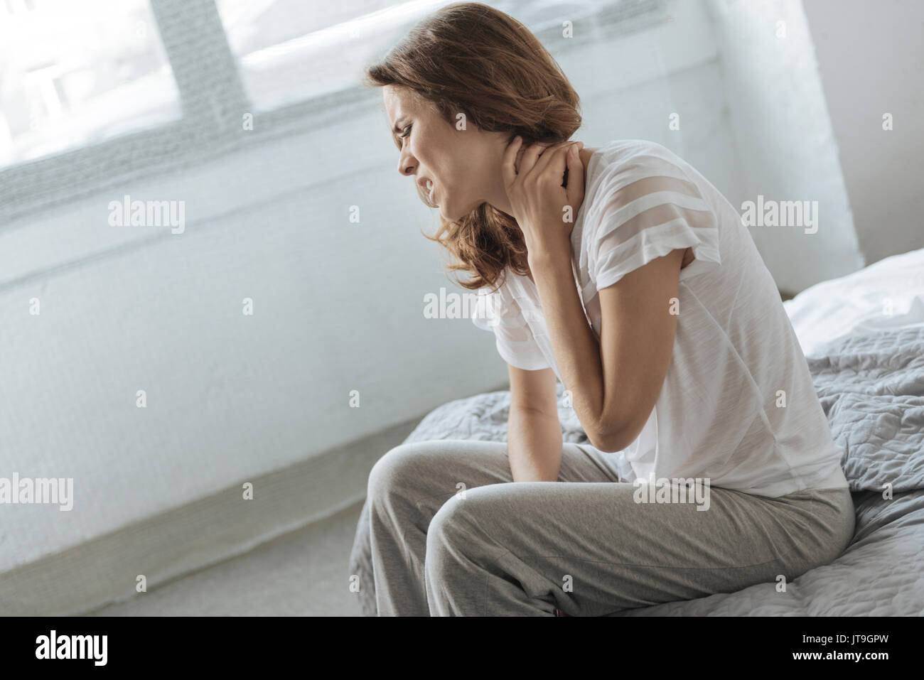 Sad depressed woman suffering from neck inflammation Stock Photo