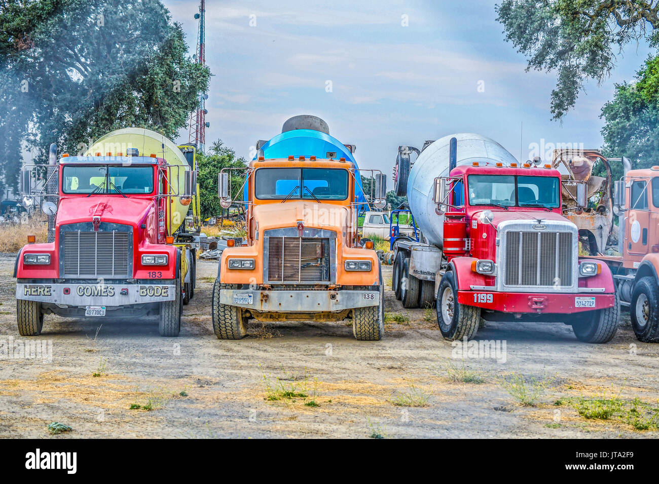 3 brightly painted cement trucks in woodland ca Stock Photo