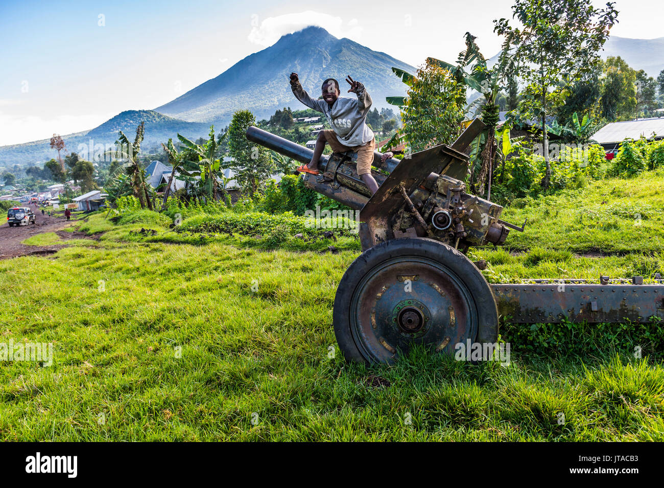 Boys posing on abandoned artillery in the Virunga National Park, Democratic Republic of the Congo, Africa Stock Photo