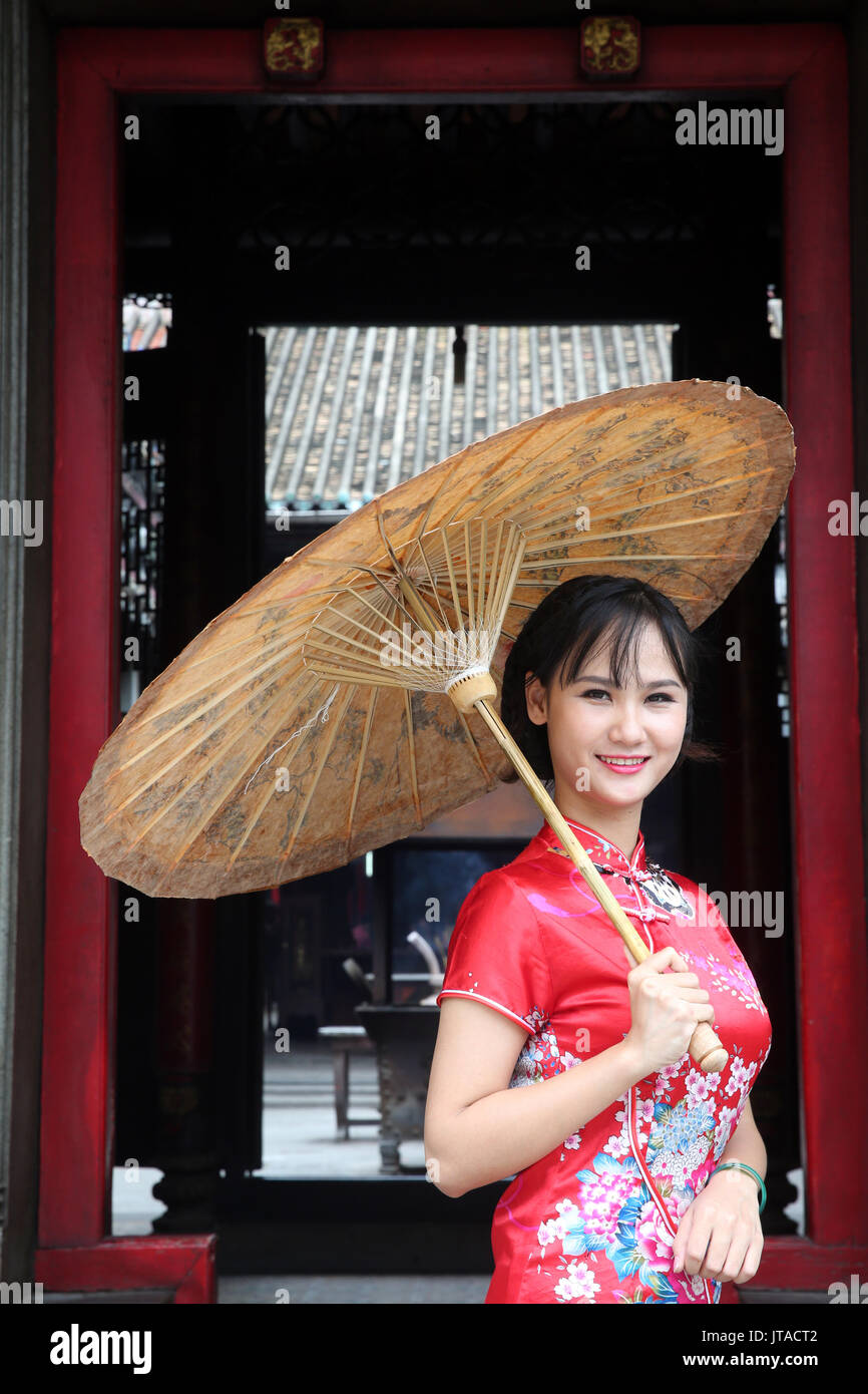 Woman wearing Vietnamese tradition dress called Ao Dai, Taoist temple, Phuoc An Hoi Quan Pagoda, Ho Chi Minh City, Vietnam Stock Photo