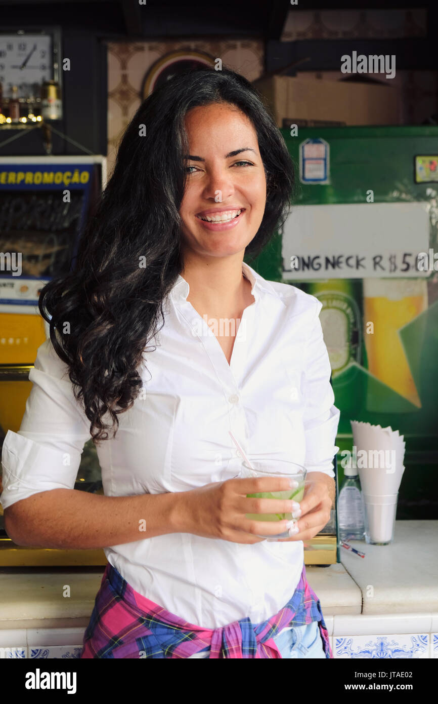 Young Brazilian woman 20 to 29 years old in a bar holding a caipirinha cocktail, Rio de Janeiro, Brazil Stock Photo