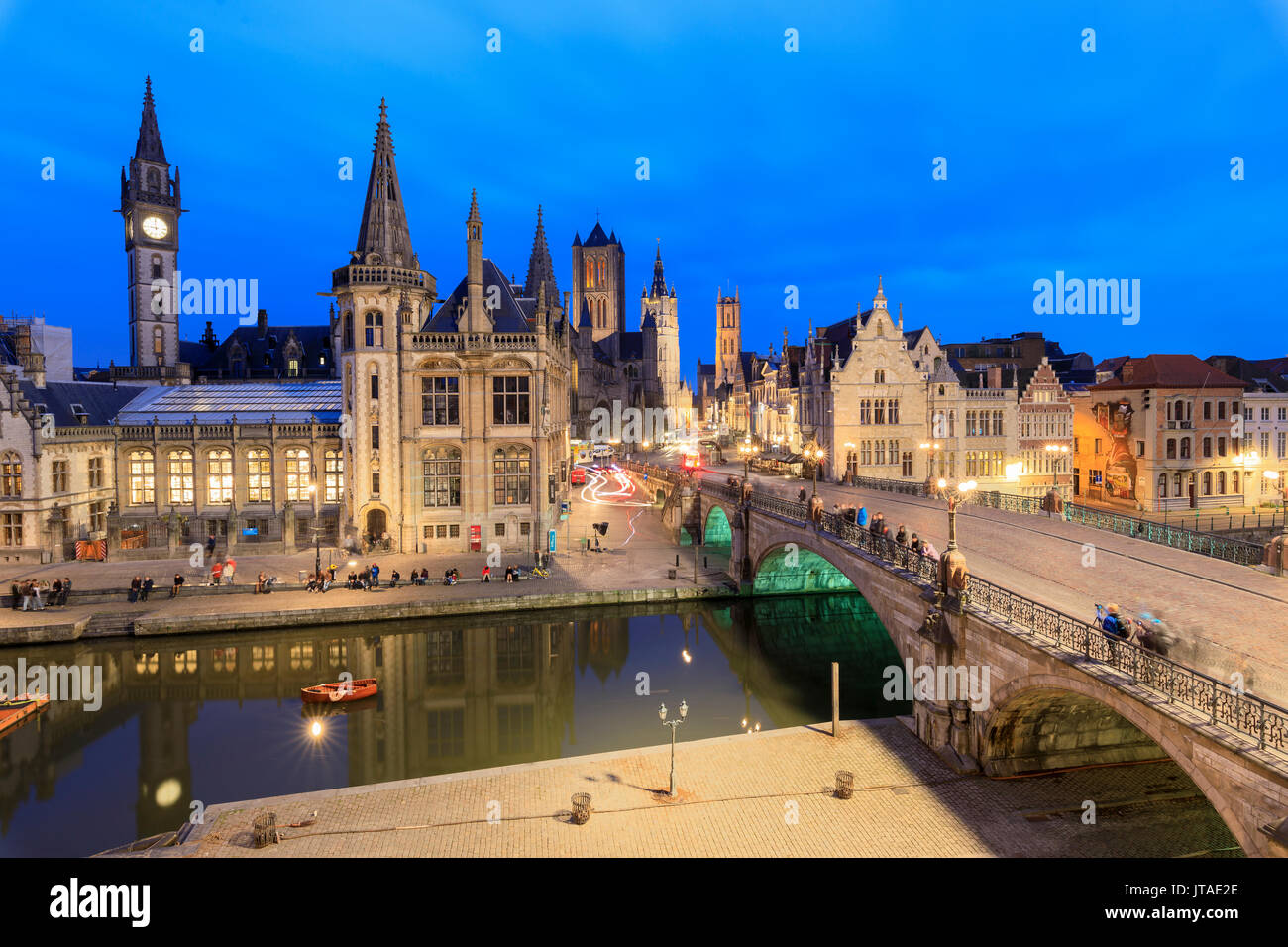 View of the historic area of Graslei and bell tower along Leie river at dusk, Ghent, Flemish Region, East Flanders, Belgium Stock Photo