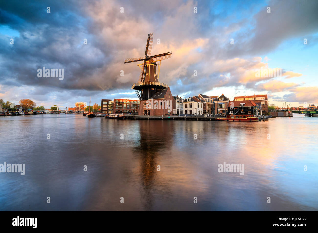 Pink clouds at sunset on the Windmill De Adriaan reflected in the River Spaarne, Haarlem, North Holland, The Netherlands, Europe Stock Photo