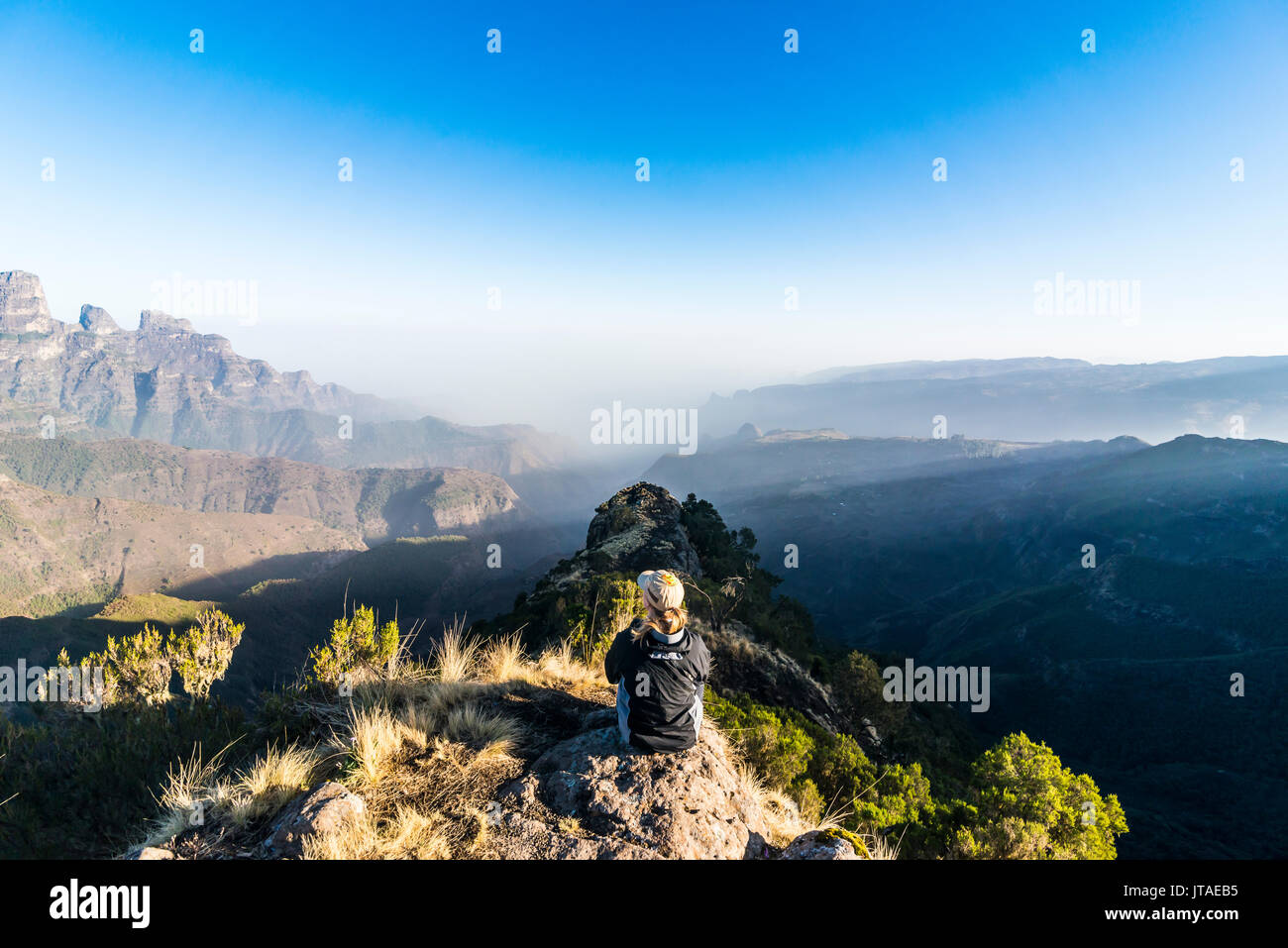 Woman enjoying the early morning sun on the cliffs, Simien Mountains National Park, UNESCO, Debarq, Ethiopia, Africa Stock Photo