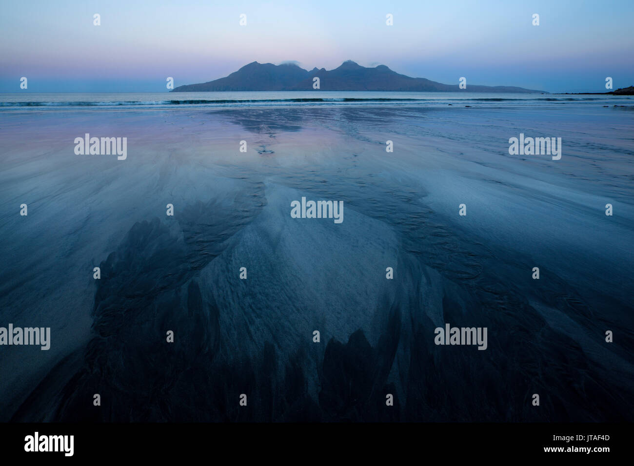 Pre-sunrise colours and view to the Isle of Rum from the beach at Laig Bay, Isle of Eigg, Small Isles, Highlands, Scotland, UK Stock Photo