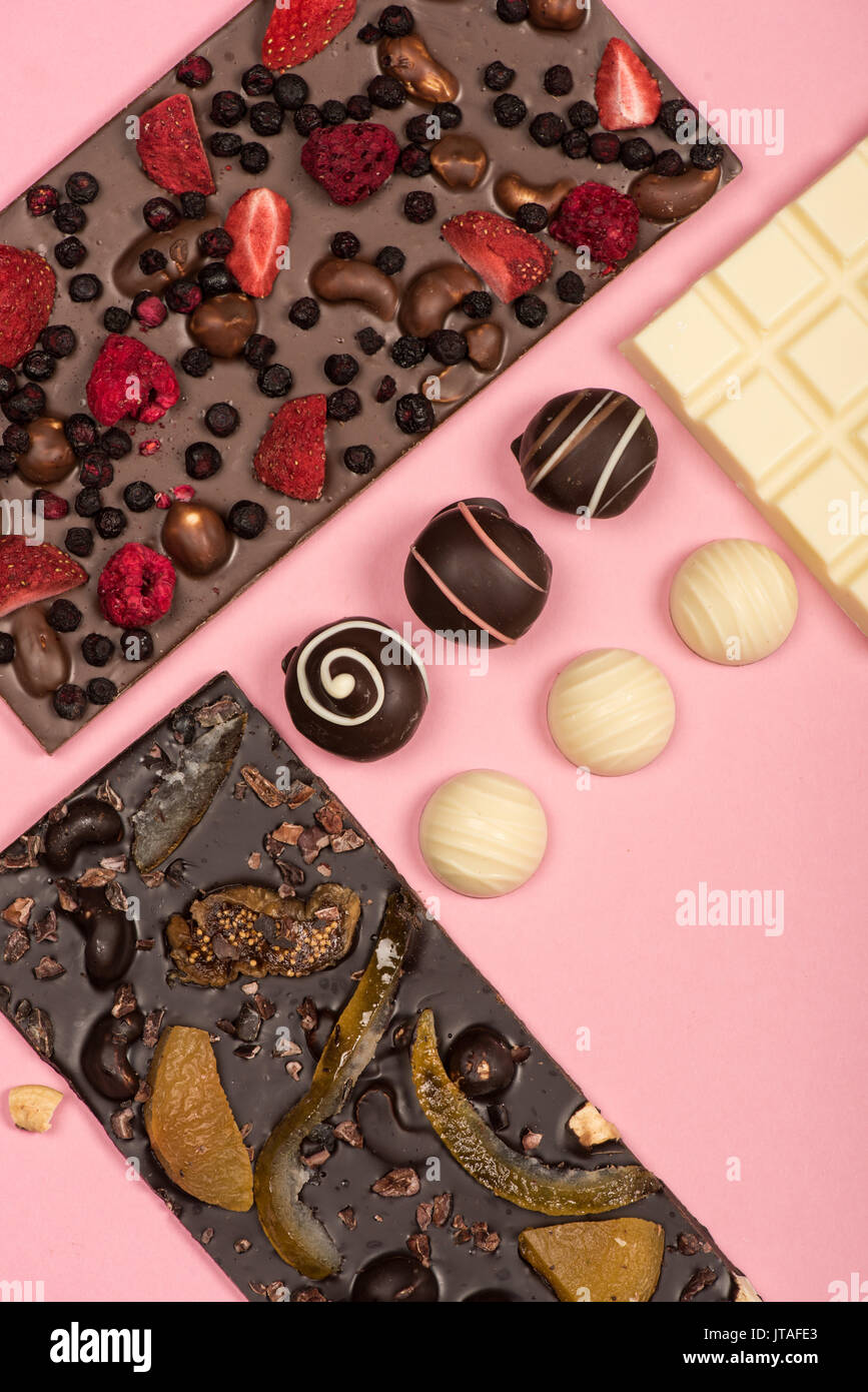 flat lay with assorted chocolate bars with fruits and nuts and candies isolated on pink Stock Photo