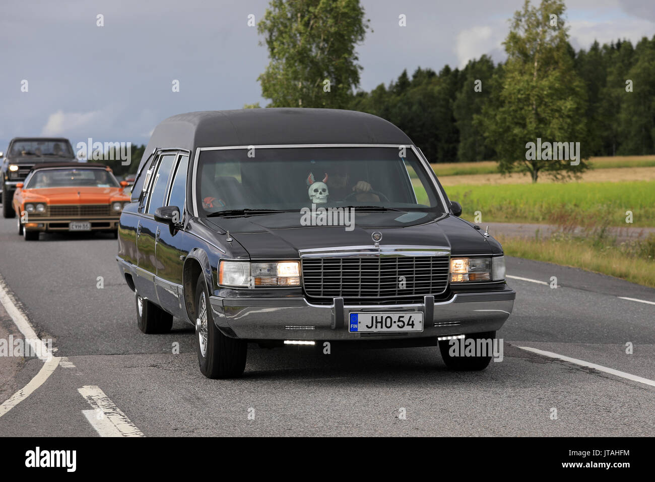 SOMERO, FINLAND - AUGUST 5, 2017: Tuned Cadillac Fleetwood funeral car with led lights and skull detail moves along scenic highway on Maisemaruise 201 Stock Photo