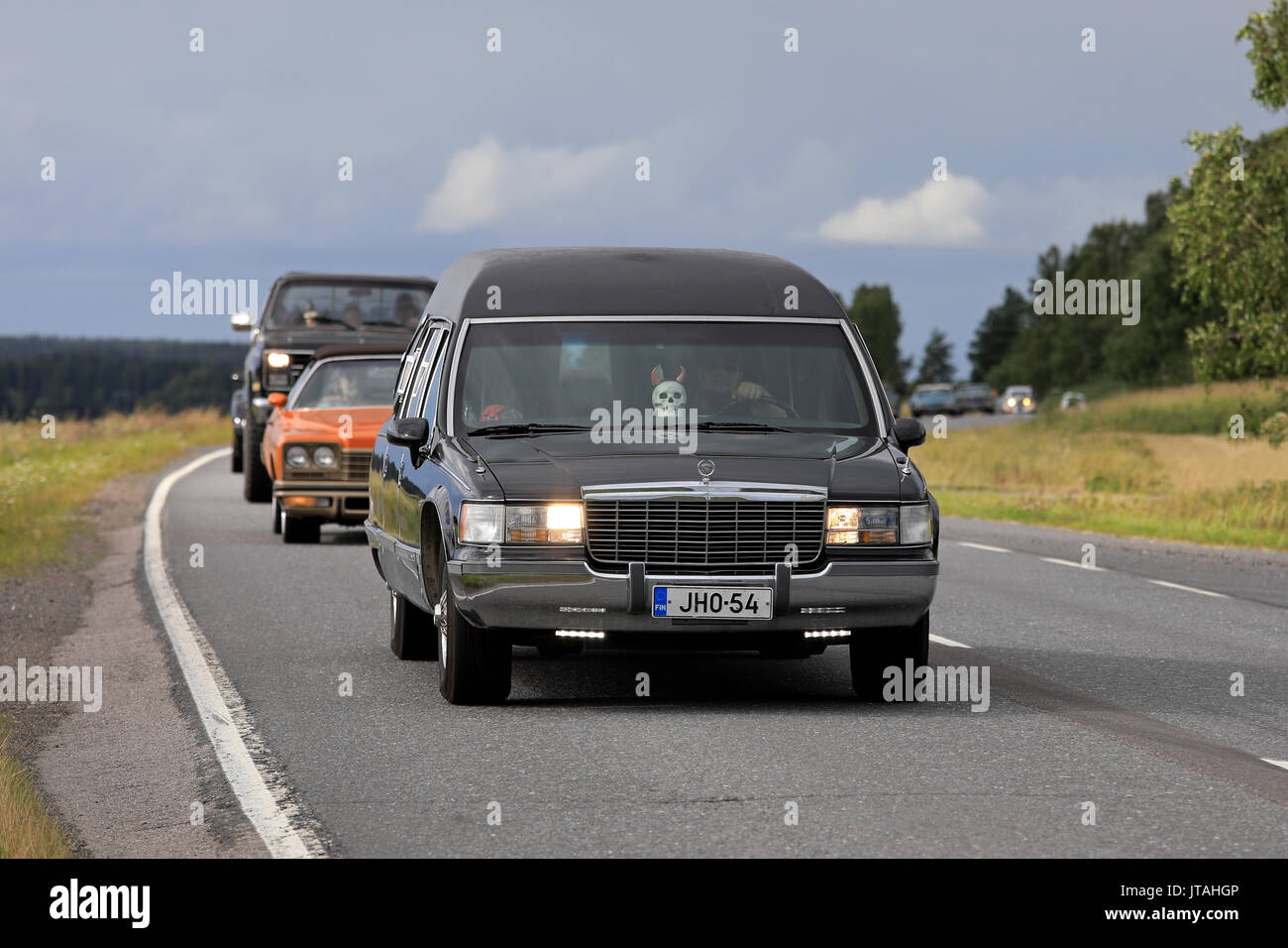 SOMERO, FINLAND - AUGUST 5, 2017: Tuned Cadillac Fleetwood funeral car with led lights and skull detail moves along scenic highway on Maisemaruise 201 Stock Photo