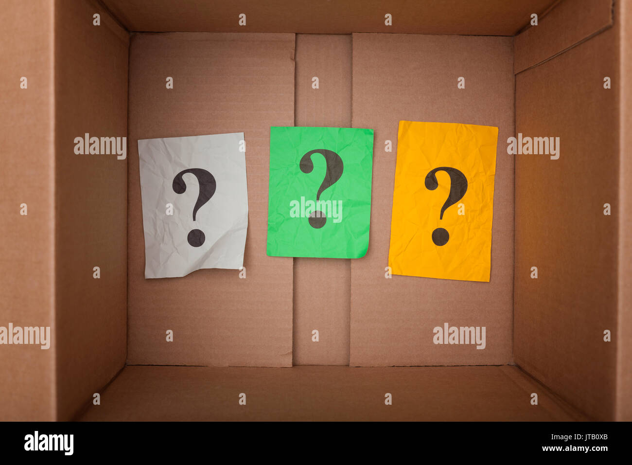 Question marks inside of a cardboard box. Close up. Stock Photo