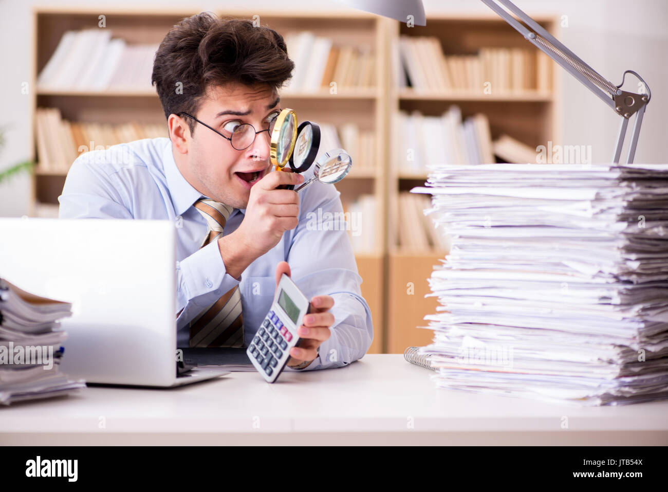 Mad auditor looking for errors in the report Stock Photo - Alamy
