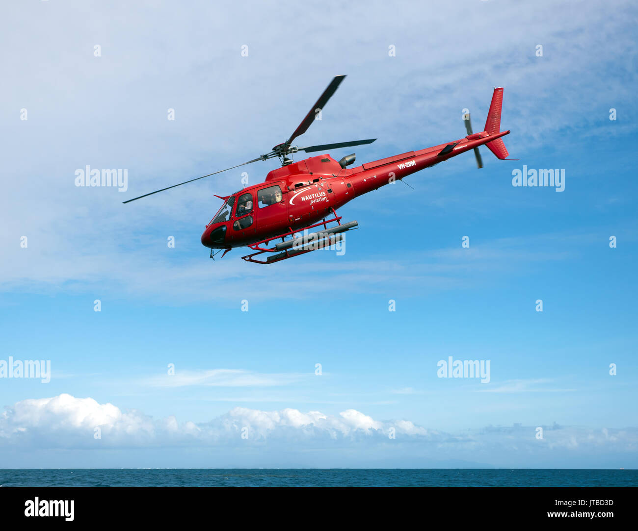 A AS350 Squirrel Helicopter, operated by Nautilus Aviation,  flying  tourists over Hastings Reef, Queensland, Australia Stock Photo
