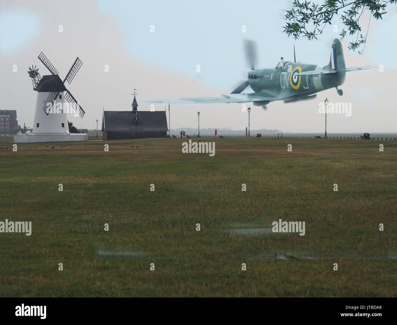 Low Flying Spitfire At Lytham Windmill, England Stock Photo