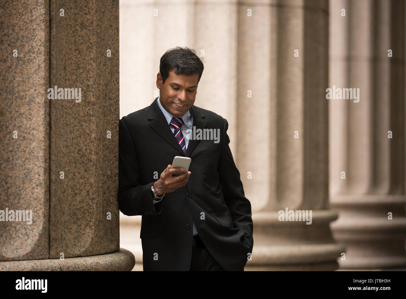 Indian businessman or Lawyer using a Smart Phone outside a colonial